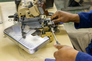 overlock machine repair african mechanic in textile industry, skilled factory workers