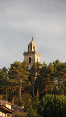 Photograph of a bell tower of a typical village in French Provence, in the light of a sunset on a summer afternoon