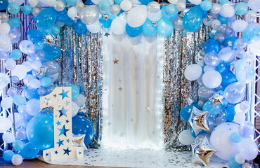 Arch blue, white and silver balloons decorate the party. Festive decorative elements, photo area. Birthday decorations with photo area, balloons, garlands and number one for a small children's party
