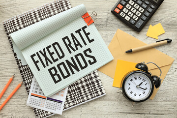Fixed rate bonds open notepad on colorful notepad. calculator. a table clock