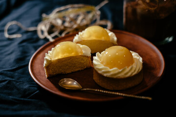 Lemon tartlets on a black background. An exquisite European dessert with fruit filling.