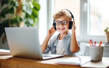 Smiling little boy in headphones have video call distant class with teacher using laptop, homeschooling concept