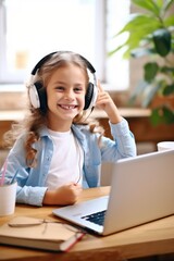 Naklejka premium Smiling little girl in headphones have video call distant class with teacher using laptop, homeschooling concept