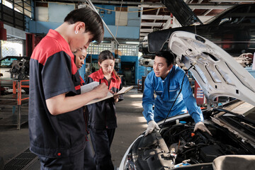 Asian male professional automotive engineer supervisor describes car engine maintenance and repair...