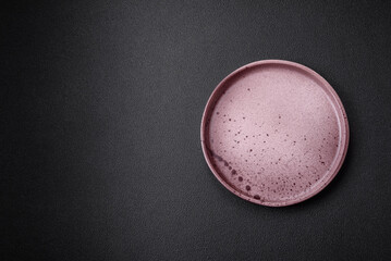 Empty round ceramic plate on a dark textured background