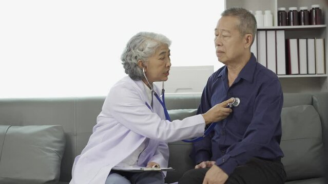 A female doctor is giving advice to an elderly man in the waiting room. Relaxed atmosphere Concept of health care, mental health