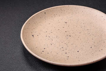 Empty round ceramic plate on a dark textured background