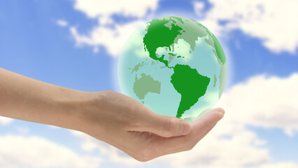 The hand of a woman holds the globe in her palm, with clouds in the background