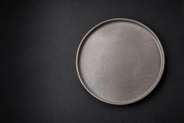 Empty round ceramic plate on a dark textured background