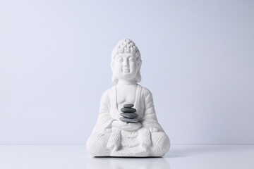 Buddha statue and stones on white background