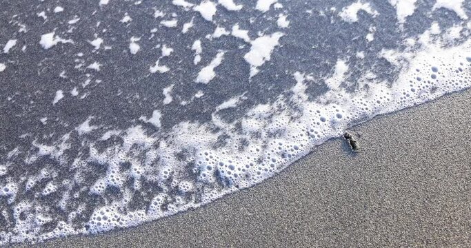 Word fear written on sand by wave foam against backdrop of sandy beach. Fear phobia of water and sea and ocean