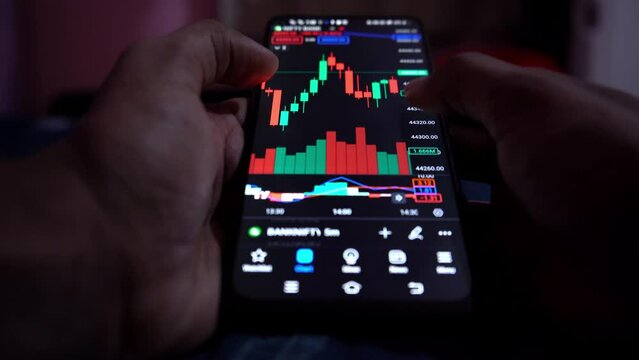 financial banker or investor analyzing stock market graph on smartphone 