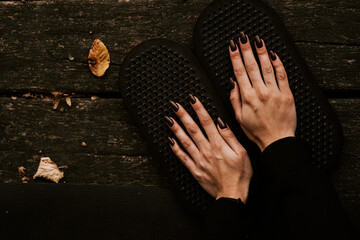 Girl posing and holding hands on Sadhu boards in autumn in the forest. Yoga and nailing concept