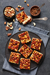 Obraz na płótnie Canvas toffee mixed nuts shortbread bars on black plate