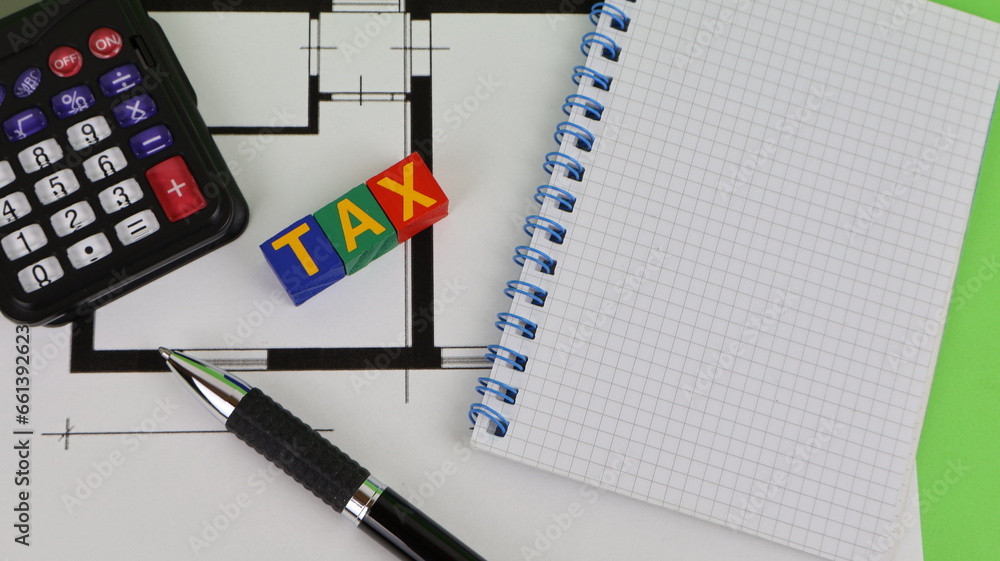 Fototapete the word tax written with wooden blocks and construction drawing with notebook, calculator on the ta