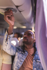 Detalhe de um jovem homem negro ajustando a vetilacao em seu assento no onibus.