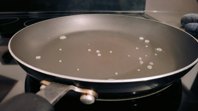 Water splashed onto teflon pan, evaporating fast. Closeup, static. pfas health concerns
