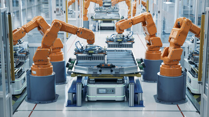 Modern Electric Car Automated Smart Factory. EV Battery Pack Production Line Equipped with Orange...