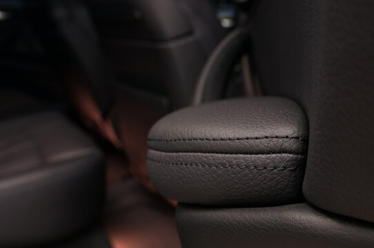 Modern business car interior detail. Leather background. Auto door armrest.