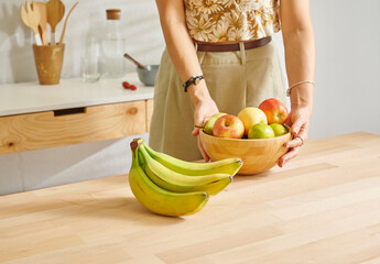 Close up fruit basket on the wooden table, kitchen, banana, apple and pear. Woman background style.