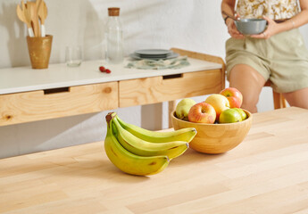 Fototapeta premium Close up fruit basket on the wooden table, kitchen, banana, apple and pear. Woman background style.