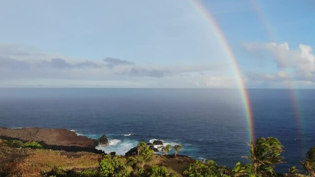 Two or double rainbow over the pacific ocean with cliffs in the foreground at sunset