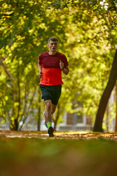 Dynamic image of man in sportswear, running, athlete in motion, training in city park. Preparation. Concept of sport, active and healthy lifestyle, competition, dynamics, marathon