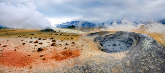 Steaming volcanic fumarole, boiling mud pit and mineral stained earth at Namaskard Geothermal Area in Iceland.