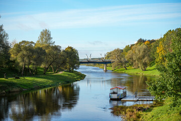 Landscape with the river Gauja in Valmiera. In the foreground, a tourist raft and a bridge in the background.