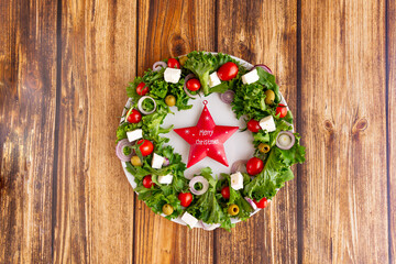 Close-up of the Christmas wreath salad with vegetables and feta cheese on the dark background....