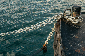 Obraz premium Rusty and anchor chain on mooring bollard