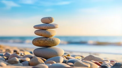 Foto op Plexiglas Balanced pebbles pyramid on the beach on sunny day and clear sky at sunset. Blue sea on background. Selective focus, bokeh. Zen stones on sea beach, meditation, spa, harmony, calm, balance concept. © HN Works