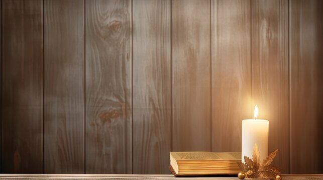 Banner image of Candle with bible on a old oak wooden table. Beautiful gold background. Religion concept.