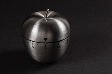 Metal apple kitchen timer on dark background