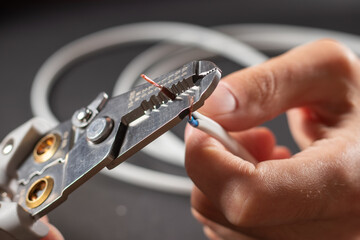 The use of the stripper cutter tool to strip the end of the electrical wire
