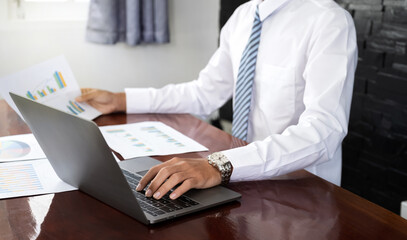 Businessmen bookkeeper hand use laptop analysis the graph for Setting challenging business goals and ready to achieve target at home office