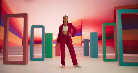 Tracking Low Angle Portrait of a Fashionable Young Woman Performing a Catwalk in a Colorful Neon Studio. Stylish Female Walking Confidently In and Out of a Bright Lit Room - Powered by Adobe