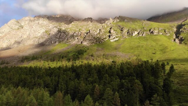 Beautiful mountain valley with green forest and high peaks. Aerial drone showing a beautiful landscape with large rocks. 
