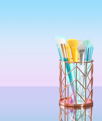 Set of colorful brushes for makeup or applying facial masks in a holder. Copy space for text.