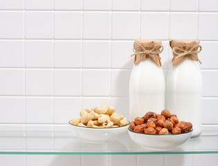 Bottles with white milk. Best snack option. Nuts extend youth. Copy space for text.