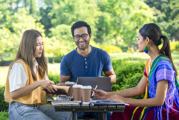 group of diverse friends,young asian male,female and transgender studying or working casually in the park on weekend,concept of people lifestyle,diversity,friendship,relationship,holiday