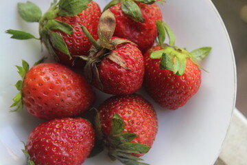 some fresh strawberries in a small plate	