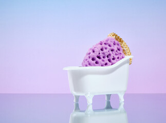 Purple sponge for water and grooming treatments in a bathtub shaped stand. Copy space for text.