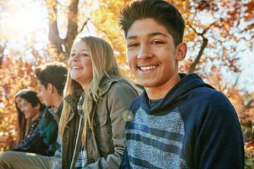 Teenager, friends and portrait in outdoor, boy and diversity on holiday, nature and relax by trees. Youth culture, happy group and gen z school kids in sunshine, woods or park for vacation in Canada