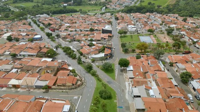 Vista a&eacute;rea de bairro residencial na cidade de Paul&iacute;nia com casas de telhado laranja e muitas &aacute;rvores e vegeta&ccedil;&atilde;o ao redor. Brasil, 2023.