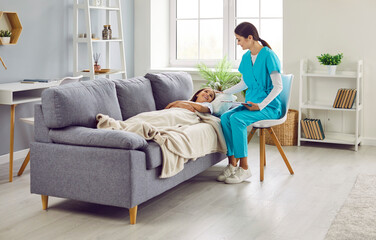 Portrait of a teenage sick smiling girl lying on the sofa at home and listening advice from a friendly female nurse. Doctor pediatrician giving consultation to a child patient. Health care concept.