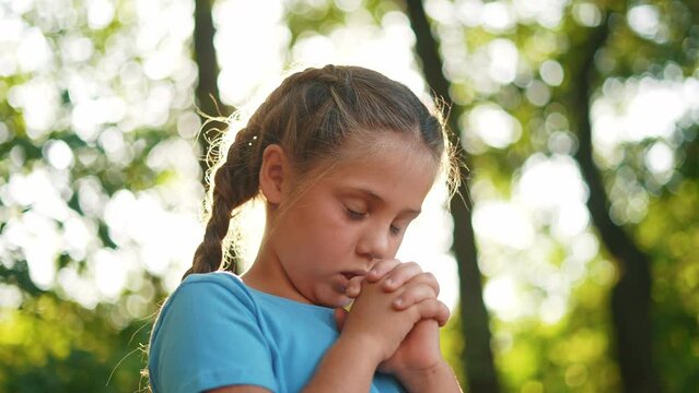 child pray. young gratitude a god religion concept. little girl in nature outdoors praying dreams of happiness lifestyle to god. praise worship freedom concept. kid praying in the forest