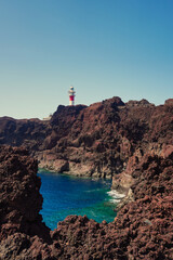 Fototapeta na wymiar The Punta de Teno lighthouse is one of the seven lighthouses that mark the coasts of the island of Tenerife (Canary Islands, Spain). It is built on the sea cliffs of the Teno rural park.