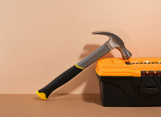 Hammer and tool box on a beige background. DIY tools set.
