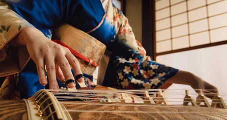 Foto op Canvas Authentic Japanese Koto Player Practising the Art of String Music in Her Traditional Home. Musician in Blue Kimono Using a Long Japanese Board Zither with 13 Silk Strings and Movable Bridges © Kitreel